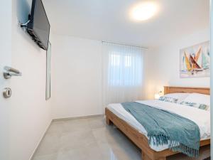 a bedroom with a bed and a flat screen tv at Apartment Ilux-1 by Interhome in Novigrad Dalmatia