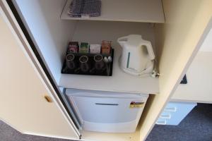 a refrigerator with a washer and dryer in a cabinet at Greenslopes Motor Inn in Brisbane