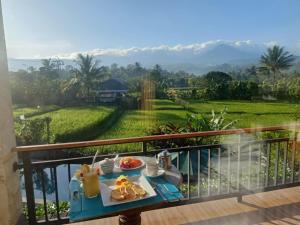 uma mesa com uma bandeja de comida numa varanda em The Aroma Villa Munduk em Mayong