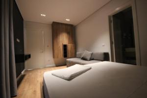 a hotel room with two beds and a couch at Le Rêve Boutique Hotel in Dhërmi