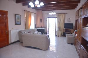 sala de estar con sofá, sillas y TV en Villa Eleni Peritheia BY CorfuEscapes, en Agios Spiridon, Corfú