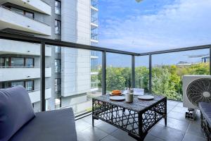 balcón con mesa y vistas a un edificio en Wola Luxury Stay en Varsovia