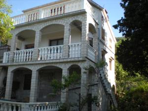 - un ancien bâtiment avec un balcon sur le côté dans l'établissement Apartments by the sea Merag, Cres - 11791, à Cres