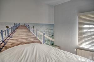 a boardwalk leading to the ocean with a bed at Beautiful city center apartments in Ghent near medieval castle in Ghent