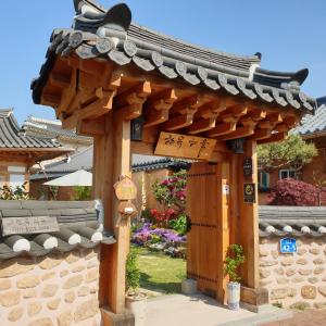 a wooden pergola in a garden with flowers at Hanok Hyeyum in Jeonju