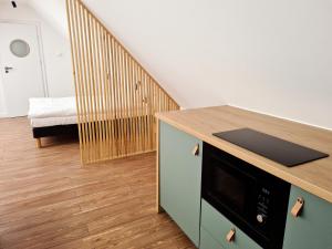 a kitchen with a counter with a microwave and a staircase at Pokoje na Szlaku Kajki 20A in Mikołajki