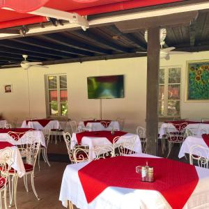 un comedor con mesas y sillas rojas y blancas en Hotel Fonte dei Fiori en Caslano