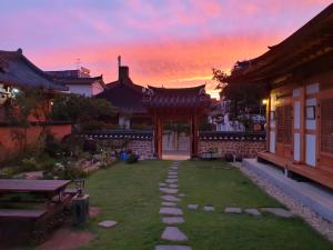 a garden with a pathway in front of a building at Hanok Hyeyum in Jeonju