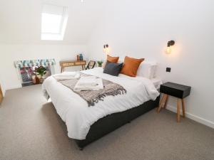 a bedroom with a large bed with orange pillows at Stabal in Gwalchmai
