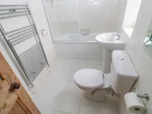 a white bathroom with a toilet and a sink at Church View Cottage in Bishop Auckland