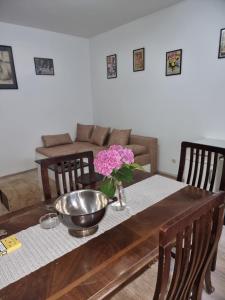 a dining room table with a bowl and flowers on it at Marakana Apartment-free parking space 2 in Dedinje