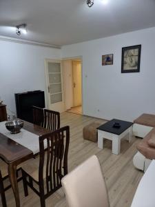 a living room with a table and a couch at Marakana Apartment-free parking space 2 in Dedinje