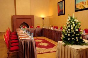 a row of tables in a room with red chairs at Art suites in El Jadida