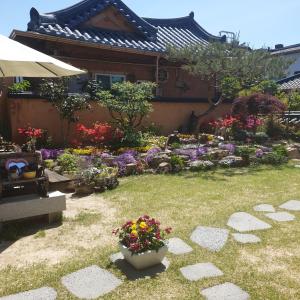 a garden with flowers in front of a house at Hanok Hyeyum in Jeonju