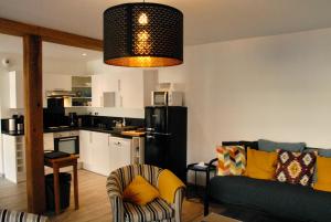 a living room with a couch and a kitchen at La maison du fond in Honfleur