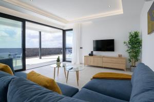un salon avec un canapé bleu et une télévision dans l'établissement Villa Ainara, à Vegas de Tegoyo