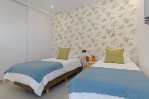 two twin beds in a room with white walls at Villa Ainara in Tías