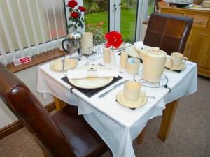 een witte tafel met twee stoelen en een witte tafel sidx sidx sidx bij Eden's Rest Bed and Breakfast in St Austell