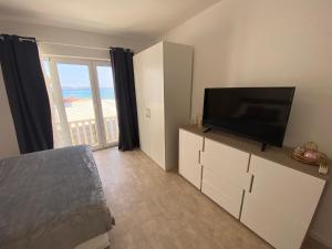 Televízia a/alebo spoločenská miestnosť v ubytovaní Beachfront Apartments and Rooms