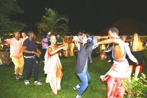a group of people dancing in the grass at Yambi Guesthouse in Kigali
