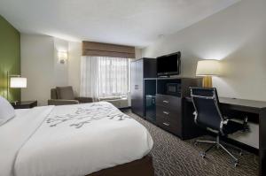 Habitación de hotel con cama, escritorio y TV. en Sleep Inn Hanes Mall, en Winston-Salem
