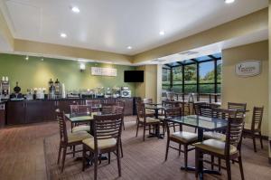 a restaurant with tables and chairs and a counter at Sleep Inn Hanes Mall in Winston-Salem