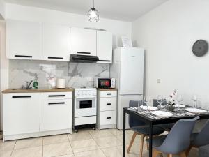 a kitchen with white appliances and a table with chairs at Albert's apartment Marina 15 in Larnaca