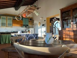a kitchen with a wooden table with a vase on it at Gatto Bianco Tizzauli in Montespertoli
