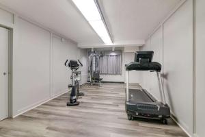a gym with treadmills and machines in a room at Econo Lodge Auburn I-95 in Auburn