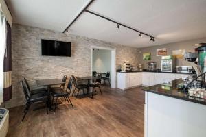 a kitchen and dining room with a table and chairs at Econo Lodge Auburn I-95 in Auburn