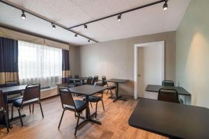 a room with tables and chairs and a window at Econo Lodge Auburn I-95 in Auburn