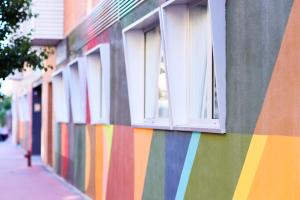 a colorful wall with windows on a building at THE APARTMENT by assethoteles in Torrejón de Ardoz