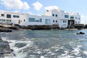 a group of white buildings next to a body of water at Casa Berriel in Punta de Mujeres
