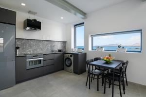 a kitchen with a table and chairs and a kitchen with the ocean at Casa Berriel in Punta de Mujeres