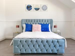 a bedroom with a blue bed with blue pillows at Week2Week 4 BEDROOM BEACH HOME Free Netflix & Wifi in South Shields