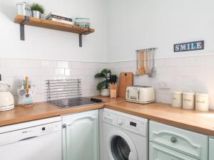 a kitchen with a washer and dryer on a counter at Week2Week 4 BEDROOM BEACH HOME Free Netflix & Wifi in South Shields