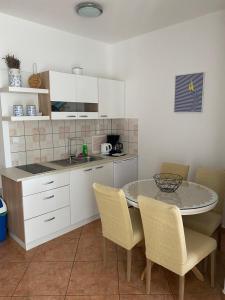 a kitchen with a table and chairs in a kitchen at Studios Simona in Medulin