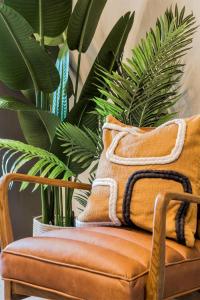 a brown chair with a pillow and plants at Your Apartment I Arabica House in Bristol