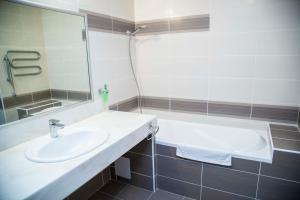 a bathroom with a sink and a bath tub at Hotel S-centrum Děčín in Děčín