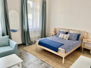 a bedroom with a bed and a chair and a mirror at Virginija Guest House in Palanga