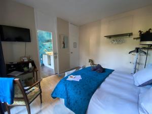 ein Schlafzimmer mit einem großen Bett mit einer blauen Decke in der Unterkunft l'hacienda in Saint-Pierre-du-Mont