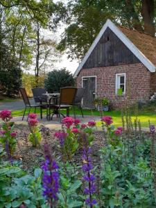 een tuin met een tafel en stoelen voor een gebouw bij Erve iemhorst in Losser