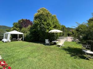 - une cour avec des chaises, une table et un parasol dans l'établissement B&b Casa Penelope, à Stiava