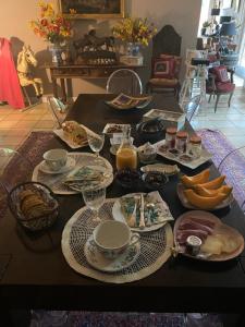 una mesa con platos de comida y vasos de zumo de naranja en l'hacienda en Saint-Pierre-du-Mont