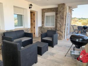 eine Terrasse mit 2 Stühlen und einem Grill in der Unterkunft Villa de Gredos in Navarredonda de Gredos