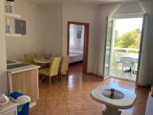 a kitchen with a table and a dining room with a balcony at Studios Simona in Medulin