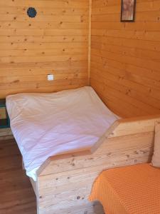 a bed in a room with a wooden wall at Вилно селище МИРОВЕЦ in Malŭk Izvor