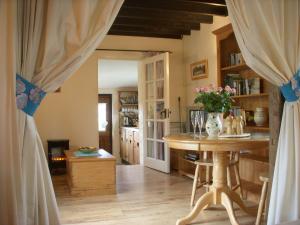 Una habitación con una mesa con un jarrón de flores. en The Nest - Thatched seaside country cottage for two en Stokeinteignhead