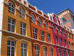 um edifício colorido com muitas janelas em Scalabrini Accommodation em Cidade do Cabo