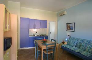 a living room with a table and a blue couch at Villetta Lilly - Belvedere Pugnochiuso - Gargano in Vieste